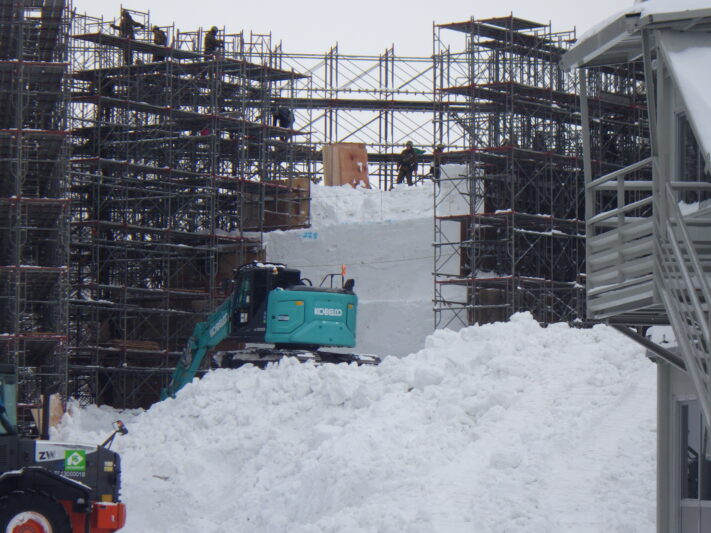 西8丁目で足場を組んで雪を重機で積み上げている陸上自衛隊の方の画像 