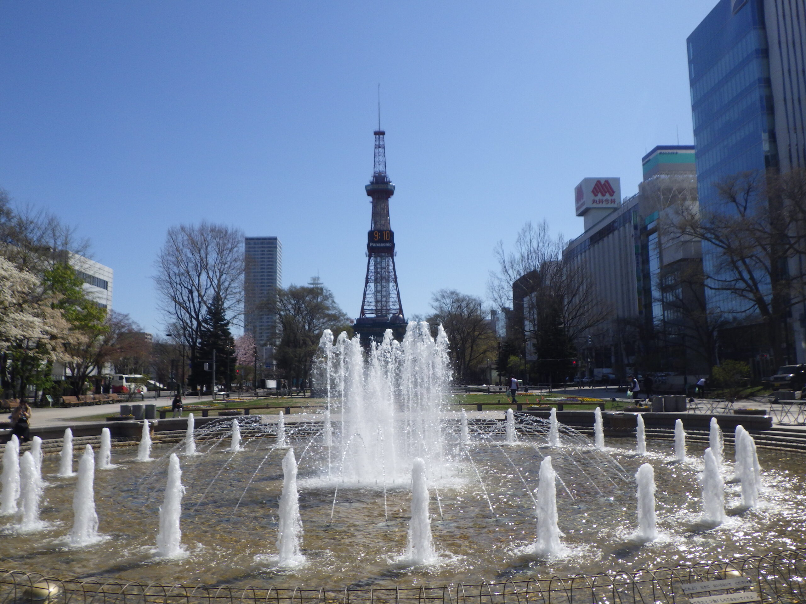 青空の中テレビ塔を背にして西3丁目噴水が水を吹き上げる画像