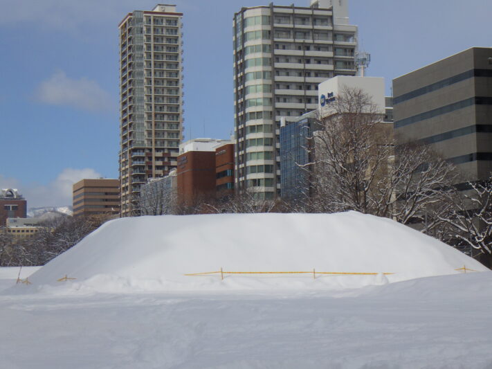 雪像解体後の雪の塊の上に新雪が積もっている画像