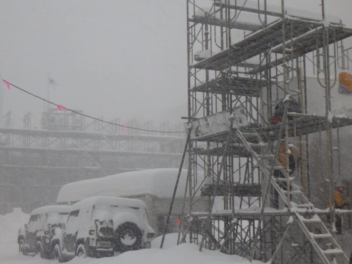 吹雪で視界が真っ白の中の大雪像制作現場の画像