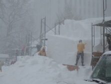 吹雪の中、雪像制作をするスタッフの画像