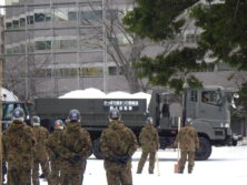 自衛隊のトラックで雪の輸送が始まり自衛隊員が見守っている画像