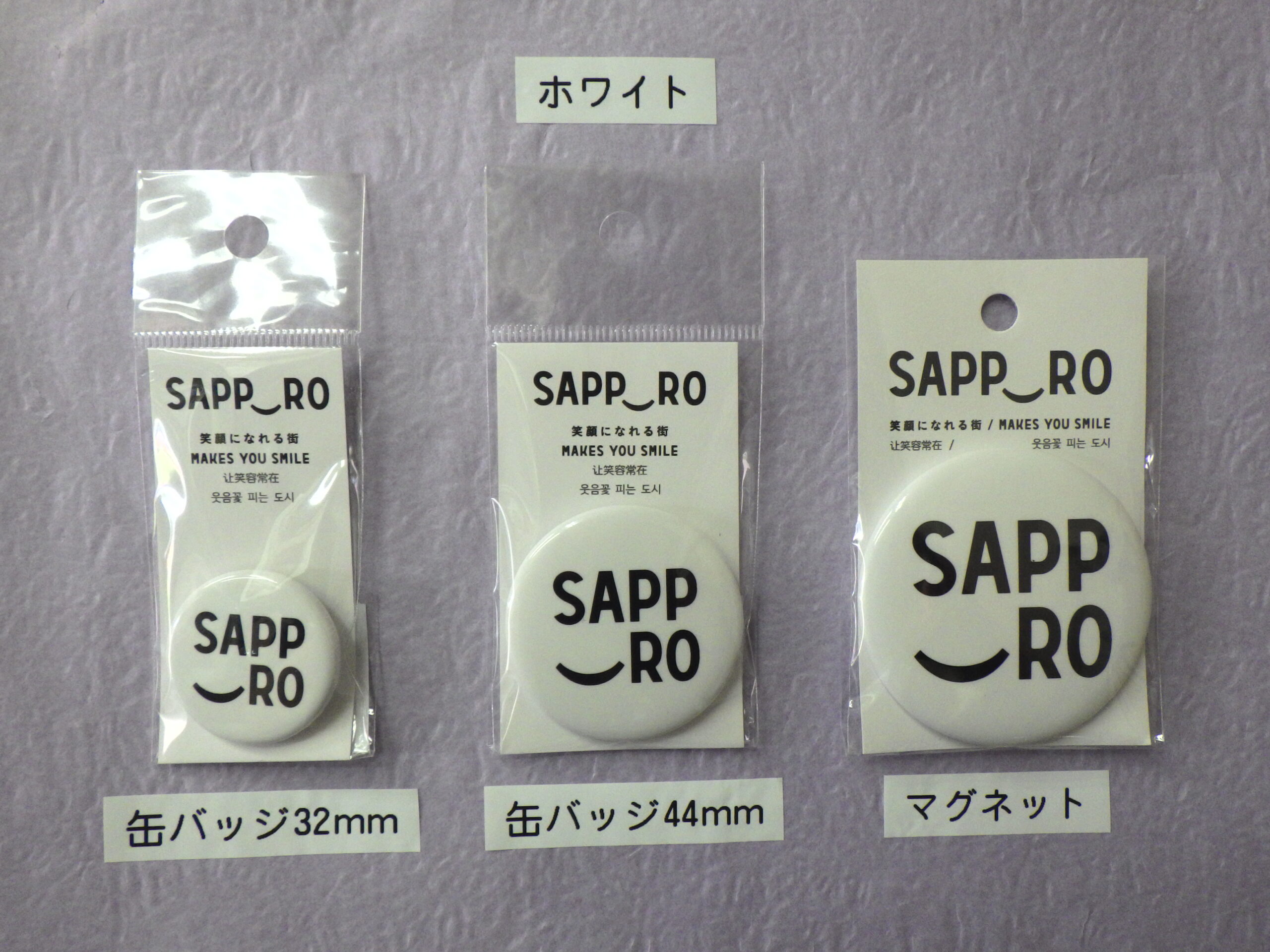 白色のサッポロスマイル缶バッジと マグネットの画像