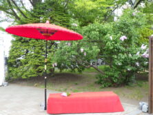 ライラックまつり会場で赤い和傘と赤い緋毛氈のベンチがあるフォトスポットの画像