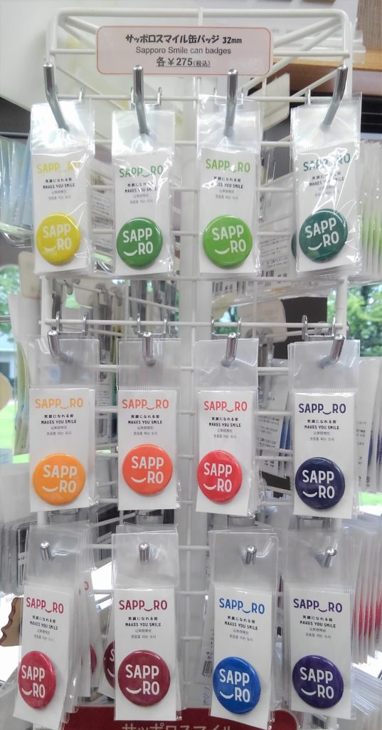 新品即決 サッポロスマイル缶バッジ32mm | 財団法人 -公益 大通公園 ピンズ・ピンバッジ・缶バッジ